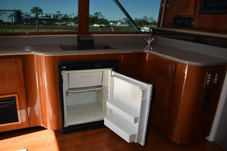  Yacht Photos Pics 2005 Egg Harbor 37 Sport Yacht interior with open mini fridge in wooden cabinetry.