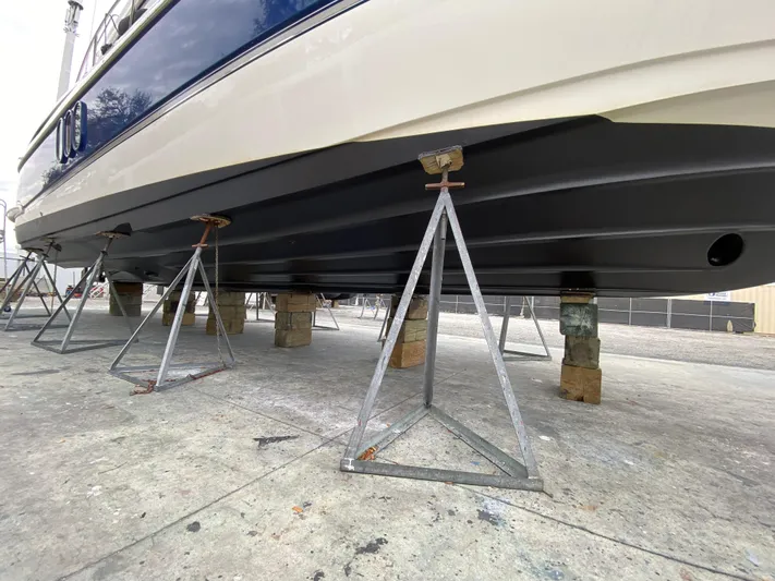 Off Line Yacht Photos Pics 2006 Cruisers Yachts 52 Express on stands, showcasing hull design.