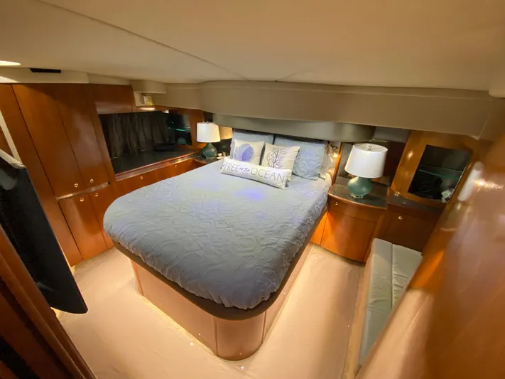 Off Line Yacht Photos Pics Luxurious bedroom in 2006 Cruisers Yachts 52 Express with elegant wood cabinetry.
