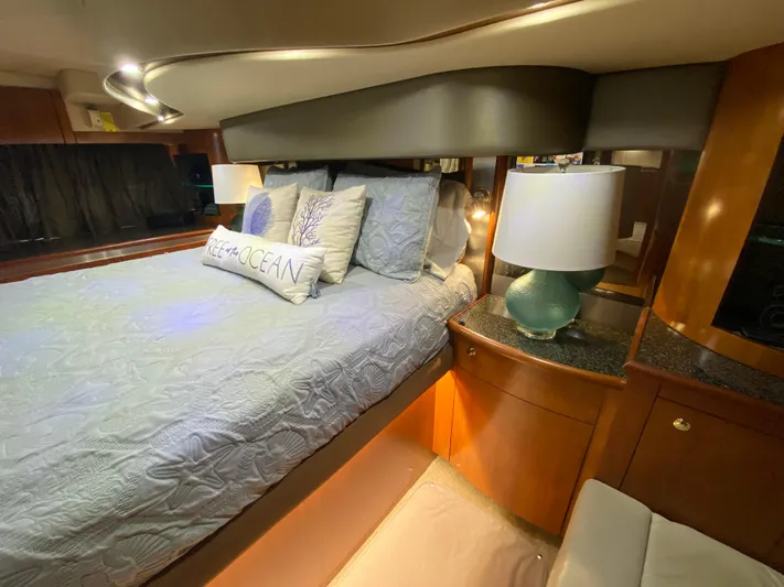 Off Line Yacht Photos Pics Luxurious bedroom interior of 2006 Cruisers Yachts 52 Express with elegant bedding and lamp.