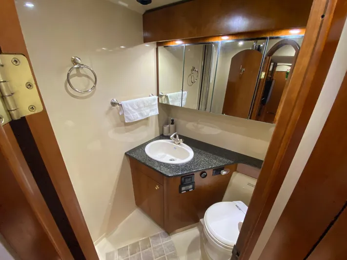 Off Line Yacht Photos Pics Luxurious bathroom in 2006 Cruisers Yachts 52 Express with modern fixtures and wood accents.