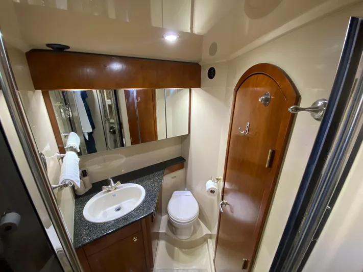 Off Line Yacht Photos Pics Luxurious 2006 Cruisers Yachts 52 Express bathroom with modern fixtures and wood accents.