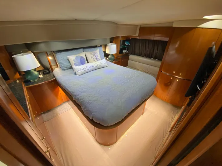 Off Line Yacht Photos Pics Luxurious bedroom interior of 2006 Cruisers Yachts 52 Express with cozy bedding and ambient lighting.