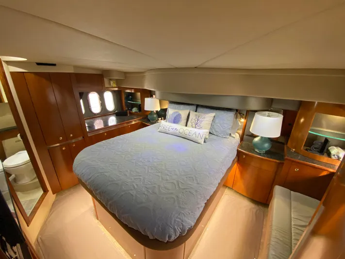 Off Line Yacht Photos Pics Luxurious bedroom in 2006 Cruisers Yachts 52 Express with elegant wood cabinetry.