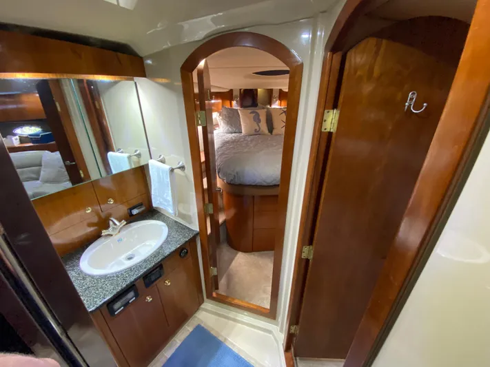 Off Line Yacht Photos Pics Luxurious 2006 Cruisers Yachts 52 Express bathroom with wood accents and cozy bedroom view.