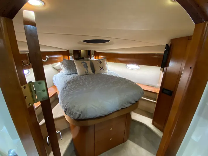 Off Line Yacht Photos Pics Luxurious cabin interior of 2006 Cruisers Yachts 52 Express with cozy bed and elegant wood finish.