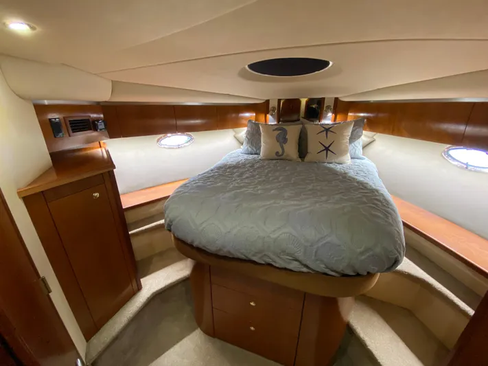 Off Line Yacht Photos Pics Luxurious bedroom interior of 2006 Cruisers Yachts 52 Express with elegant wood finish.