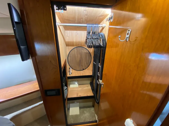 Off Line Yacht Photos Pics Wooden closet interior on 2006 Cruisers Yachts 52 Express, featuring hangers and hooks.
