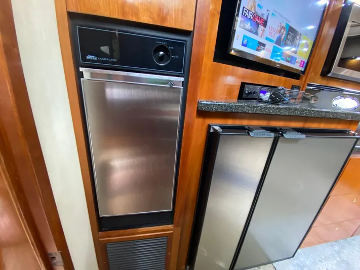 Off Line Yacht Photos Pics 2006 Cruisers Yachts 52 Express kitchen with stainless steel appliances and wood cabinetry.