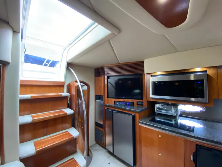 Off Line Yacht Photos Pics Interior of 2006 Cruisers Yachts 52 Express with modern kitchen and entertainment area.