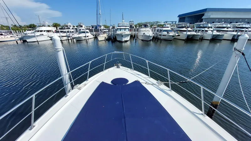 Off Line Yacht Photos Pics 2006 Cruisers Yachts 52 Express docked in a marina, surrounded by other boats.