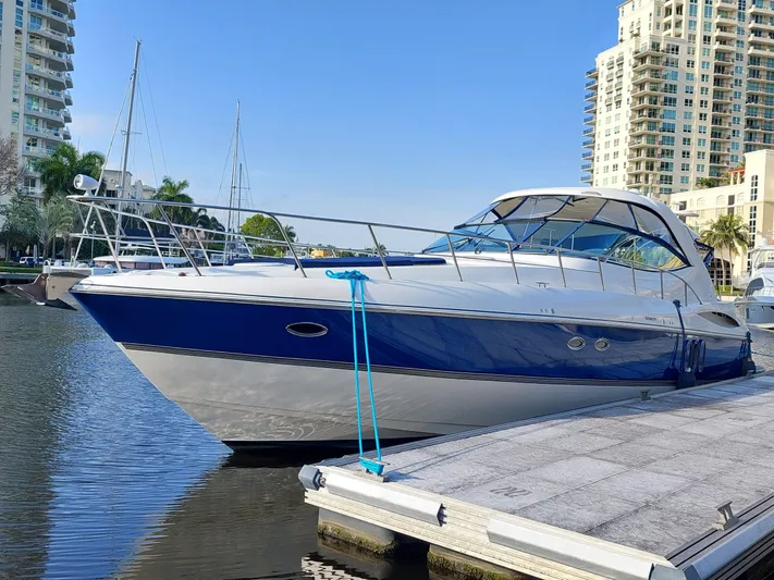 Off Line Yacht Photos Pics 2006 Cruisers Yachts 52 Express docked in a marina, surrounded by tall buildings.