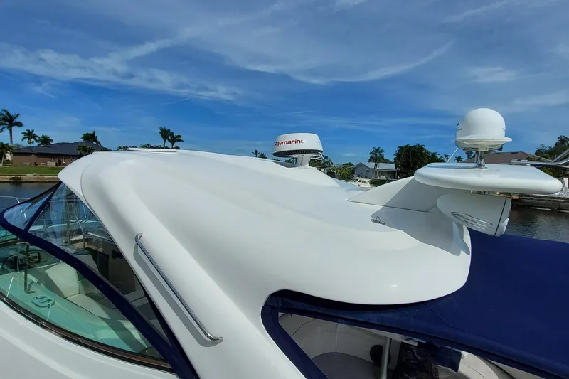 Off Line Yacht Photos Pics 2006 Cruisers Yachts 52 Express, sleek design, docked under clear blue sky.