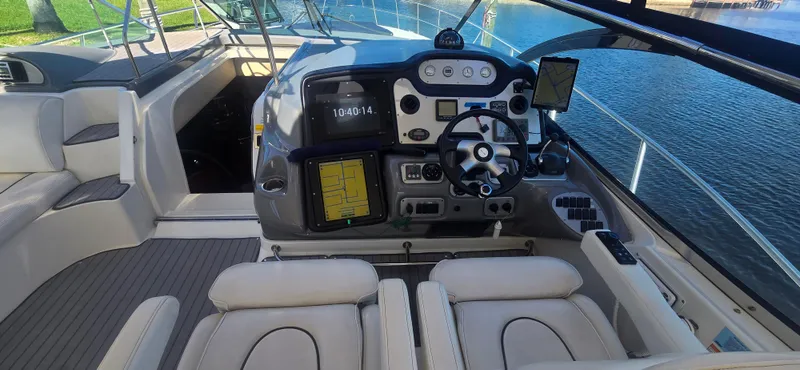 Off Line Yacht Photos Pics 2006 Cruisers Yachts 52 Express helm with modern navigation equipment and comfortable seating.