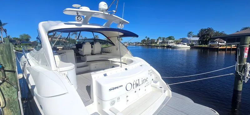 Off Line Yacht Photos Pics 2006 Cruisers Yachts 52 Express docked by a serene waterfront.