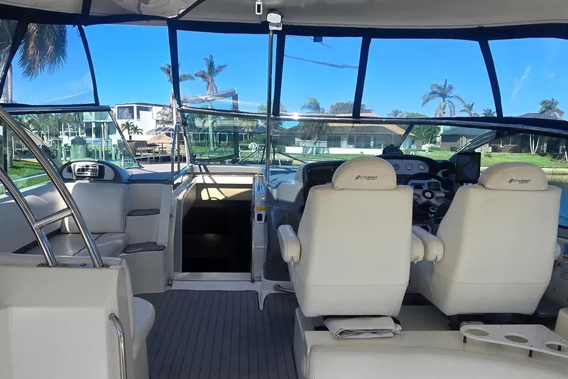 Off Line Yacht Photos Pics Interior view of 2006 Cruisers Yachts 52 Express, featuring helm and seating area.