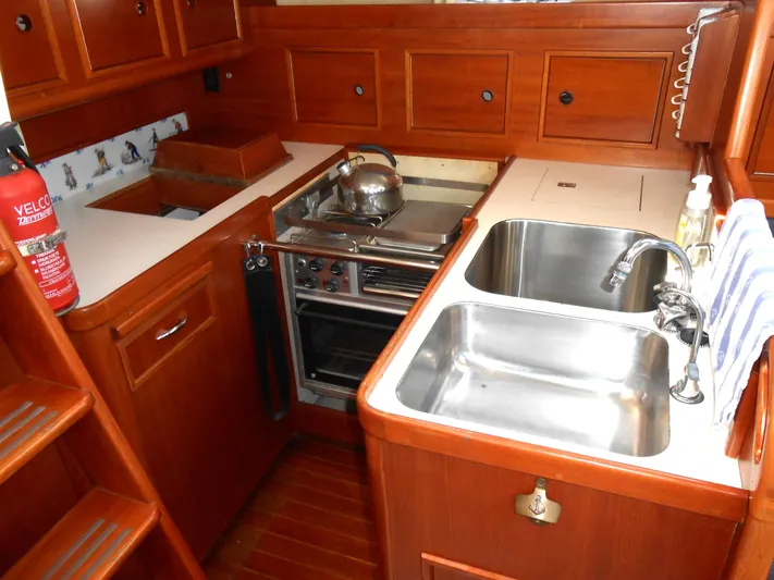 Dutchess Yacht Photos Pics 1985 Contest 41 Ketch yacht kitchen with stove, sink, and wooden cabinetry.