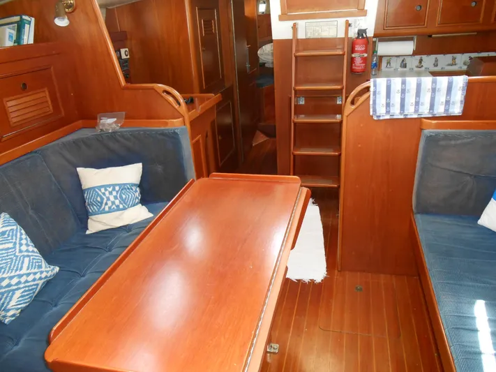 Dutchess Yacht Photos Pics Interior of 1985 Contest 41 Ketch sailboat with wooden furnishings and blue seating.