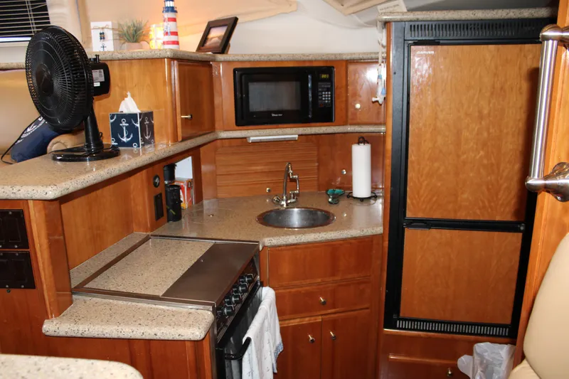  Yacht Photos Pics Interior of 2002 Carver 356 Motor Yacht kitchen with wood cabinetry and appliances.