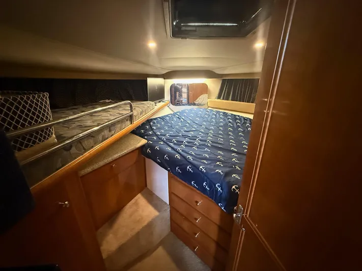  Yacht Photos Pics Interior cabin of 2002 Carver 356 Motor Yacht with cozy bedding and wooden cabinetry.