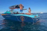 2020 MasterCraft X26 boat on water with two people enjoying the sun.
