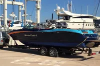 2020 MasterCraft X26 boat on trailer at marina, surrounded by yachts.