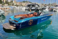 2020 MasterCraft X26 boat docked in a marina with clear blue water.