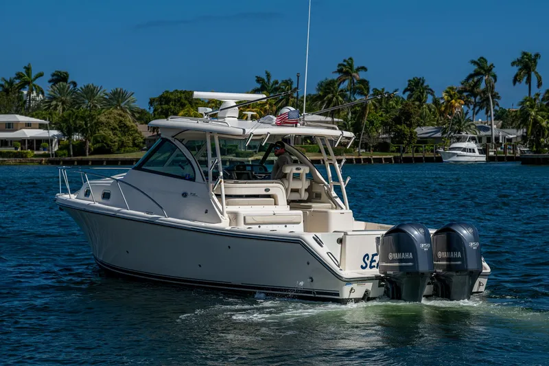  Yacht Photos Pics 2014 Pursuit 345os boat cruising on a sunny day with twin Yamaha engines.