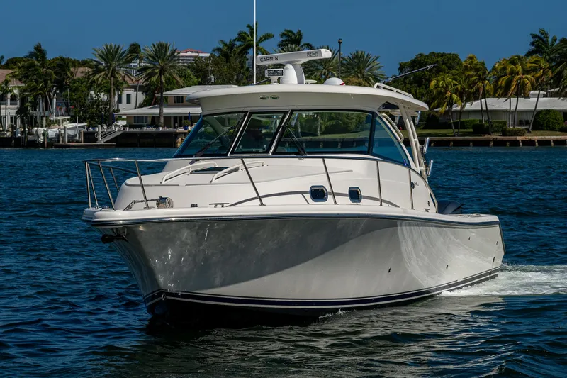  Yacht Photos Pics 2014 Pursuit 345os boat cruising on a sunny day, surrounded by palm trees.