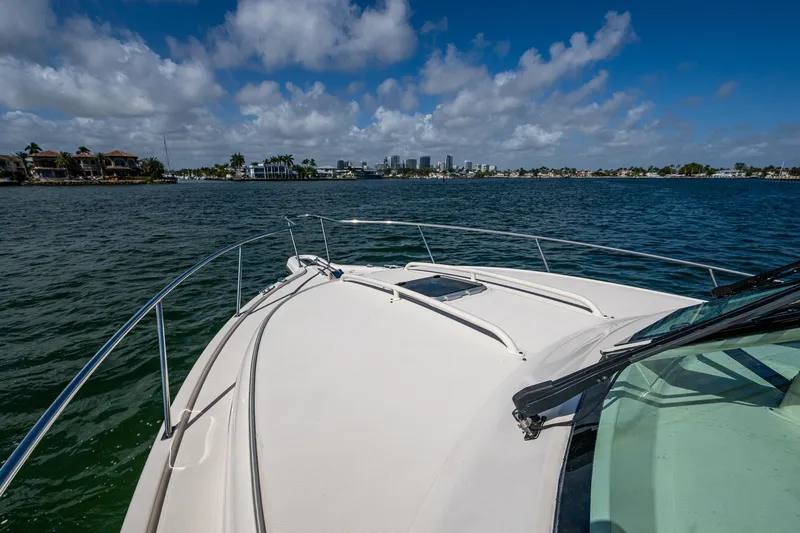  Yacht Photos Pics 2014 Pursuit 345os boat cruising on a sunny day with city skyline in background.