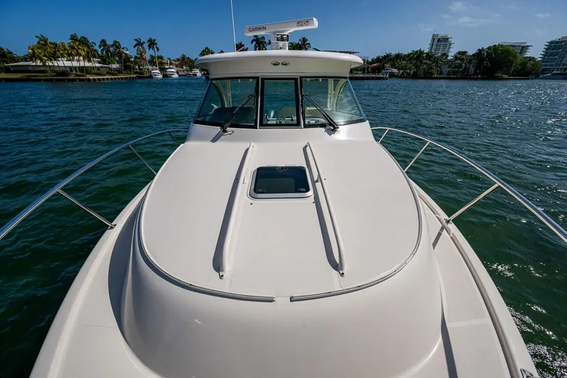  Yacht Photos Pics 2014 Pursuit 345os boat on water, sunny day, palm trees in background.