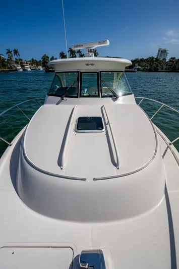  Yacht Photos Pics 2014 Pursuit 345os boat on water, clear sky, palm trees in background.