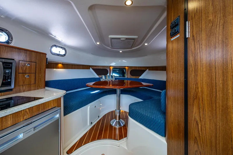  Yacht Photos Pics Luxurious interior of 2014 Pursuit 345os boat with wood accents and cozy seating area.