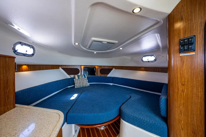  Yacht Photos Pics 2014 Pursuit 345os cabin interior with blue seating and wood accents.