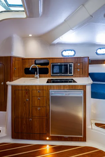  Yacht Photos Pics 2014 Pursuit 345os yacht interior kitchen with wood cabinetry, stainless steel appliances, and modern design.