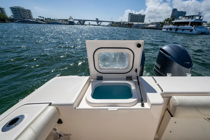  Yacht Photos Pics 2014 Pursuit 345os boat with open hatch, ocean view, and city skyline in background.