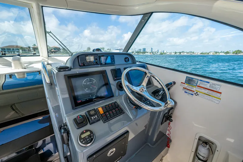  Yacht Photos Pics Helm of 2014 Pursuit 345os boat with navigation controls, steering wheel, and ocean view.