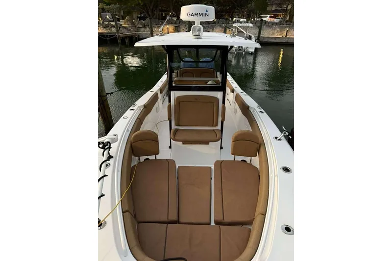  Yacht Photos Pics 2021 Sea Hunt Gamefish 30 Forward Seating boat with brown cushions, docked by the water.