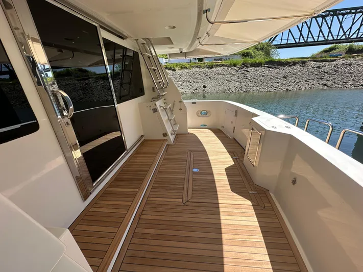 Safari Yacht Photos Pics 2001 Symbol 66 Pilothouse Yacht deck with teak flooring and water view.