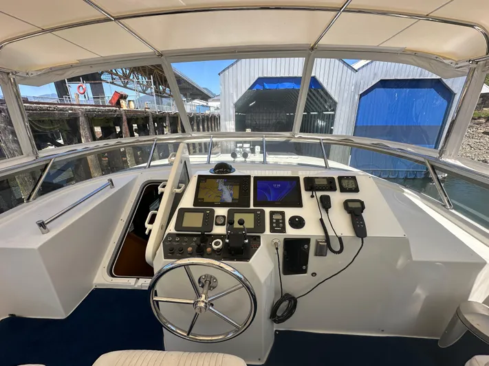 Safari Yacht Photos Pics Pilothouse of 2001 Symbol 66 Yacht with navigation equipment and steering wheel, docked at marina.