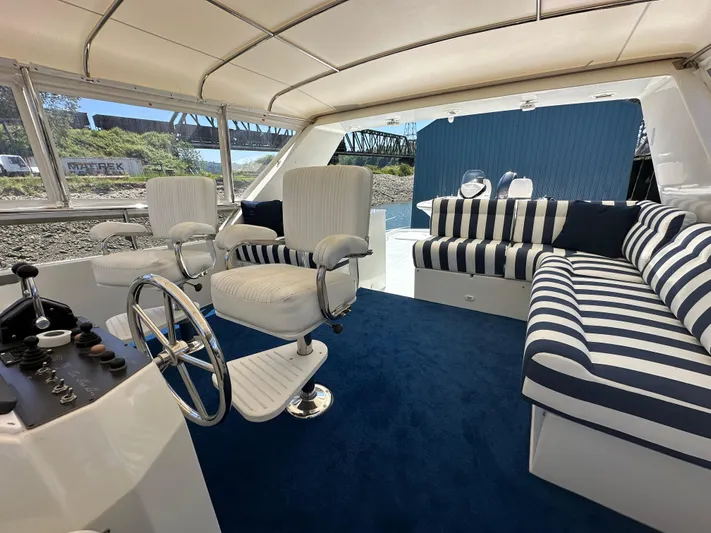 Safari Yacht Photos Pics Luxurious interior of 2001 Symbol 66 Pilothouse Yacht with striped seating and steering wheel.