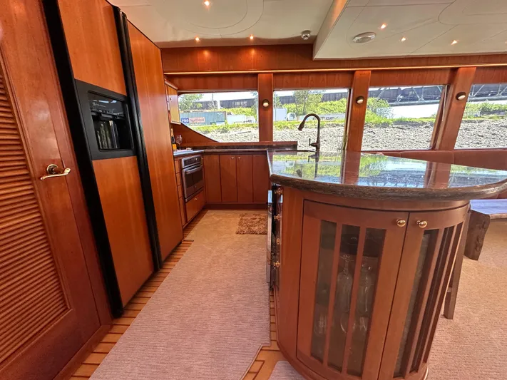 Safari Yacht Photos Pics Luxurious kitchen interior of 2001 Symbol 66 Pilothouse Yacht with wood cabinetry and large windows.