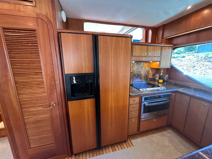 Safari Yacht Photos Pics Luxurious kitchen interior of a 2001 Symbol 66 Pilothouse Yacht with wood cabinetry.