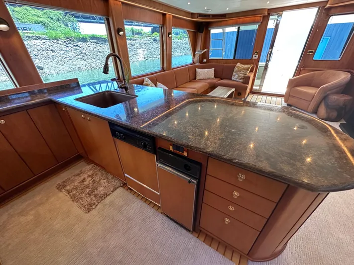 Safari Yacht Photos Pics Luxurious interior of 2001 Symbol 66 Pilothouse Yacht with modern kitchen and seating area.