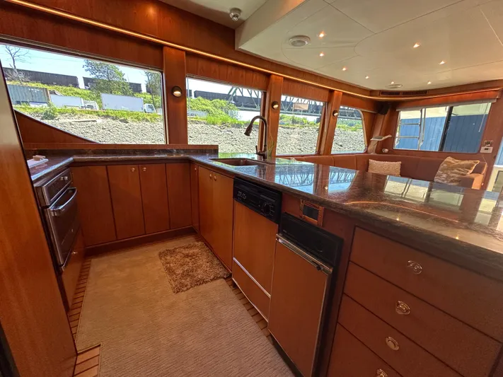 Safari Yacht Photos Pics Luxurious kitchen interior of 2001 Symbol 66 Pilothouse Yacht with wood cabinetry and large windows.