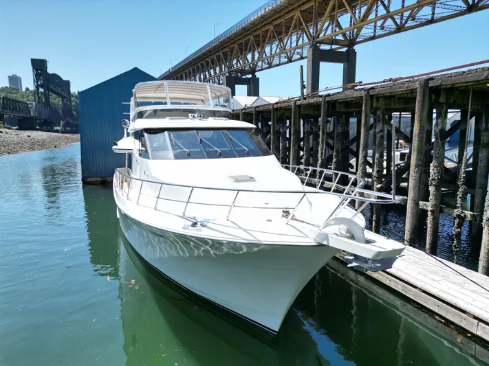Safari Yacht Photos Pics 2001 Symbol 66 Pilothouse Yacht docked near a bridge on a sunny day.