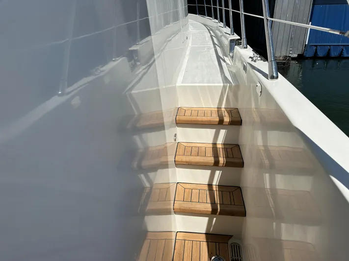 Safari Yacht Photos Pics Wooden steps on a 2001 Symbol 66 Pilothouse Yacht deck, reflecting sunlight.