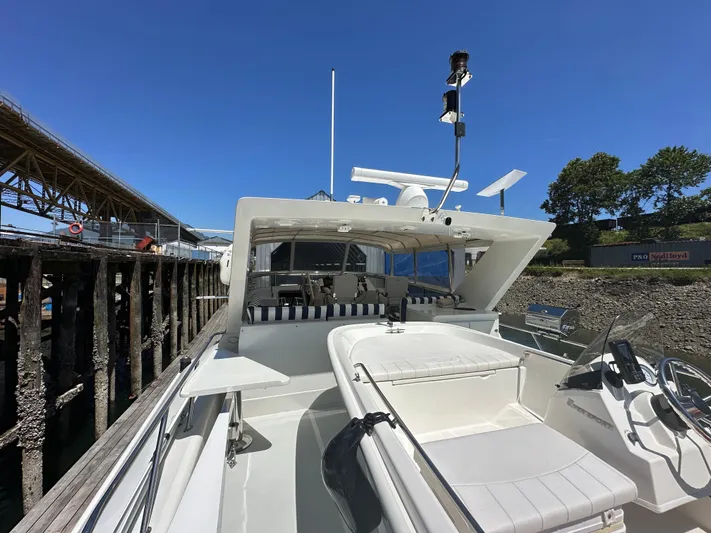 Safari Yacht Photos Pics 2001 Symbol 66 Pilothouse Yacht docked, showcasing sleek design and spacious deck under clear blue sky.