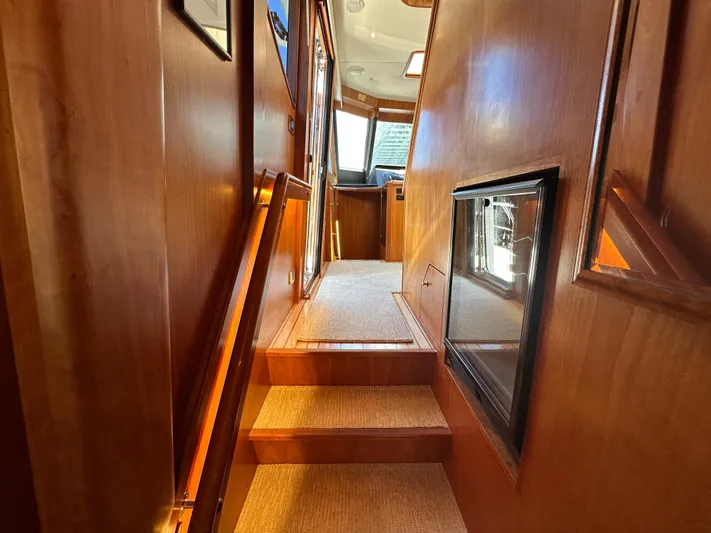 Safari Yacht Photos Pics Interior hallway of 2001 Symbol 66 Pilothouse Yacht with wooden paneling and carpeted stairs.