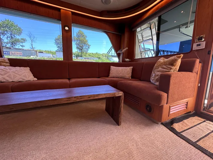 Safari Yacht Photos Pics Luxurious interior of 2001 Symbol 66 Pilothouse Yacht with plush seating and wooden accents.